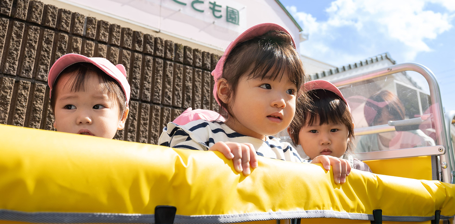 園児たちが黄色い遊具で遊ぶ様子。屋外での活動風景。